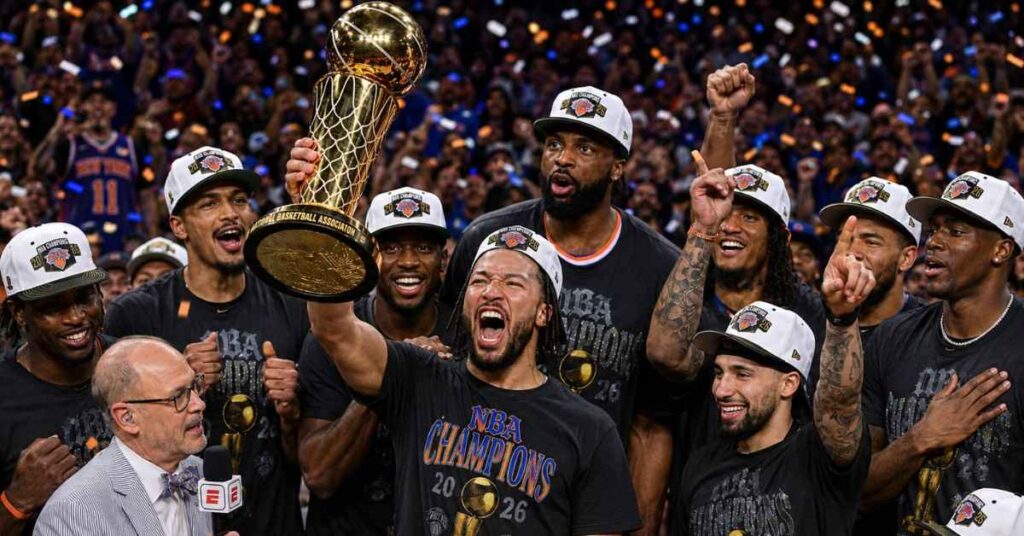New York Knicks players celebrate their 2026 NBA Championship victory with the trophy after defeating the San Antonio Spurs in Game 5 of the NBA Finals.