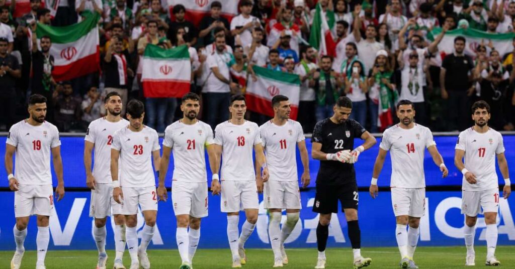 Iran players walking off at SoFi Stadium with crowd in background, post-match atmosphere.