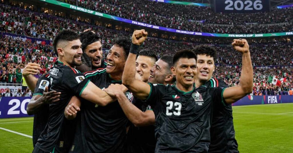 Mexican football players wearing black jerseys celebrate passionately inside a packed World Cup stadium.